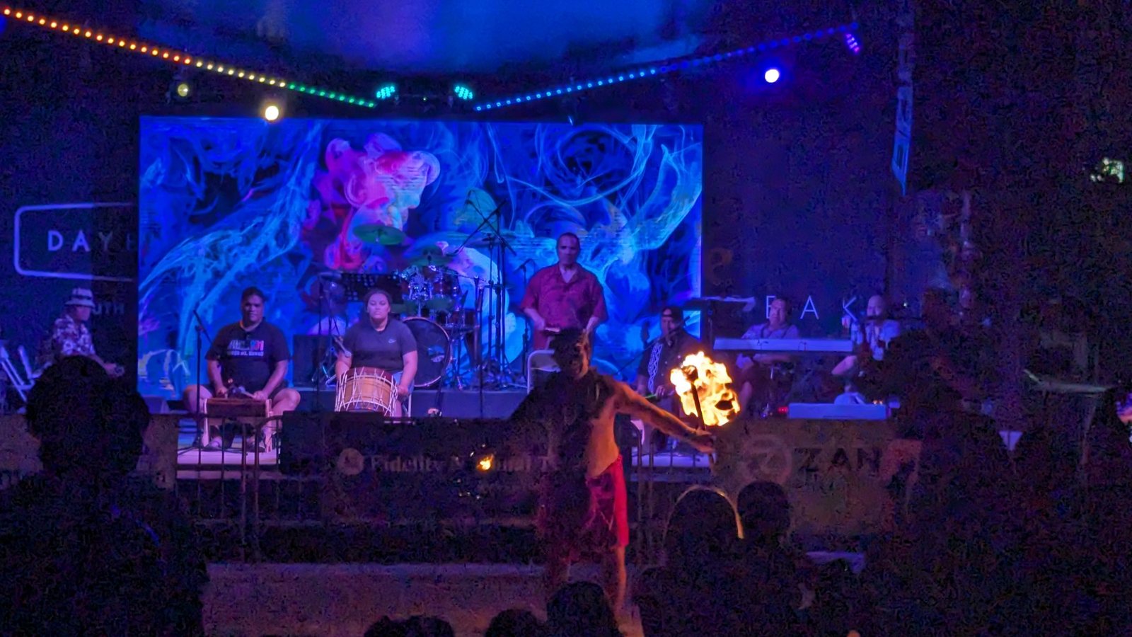 A vocalist performing under stage lighting