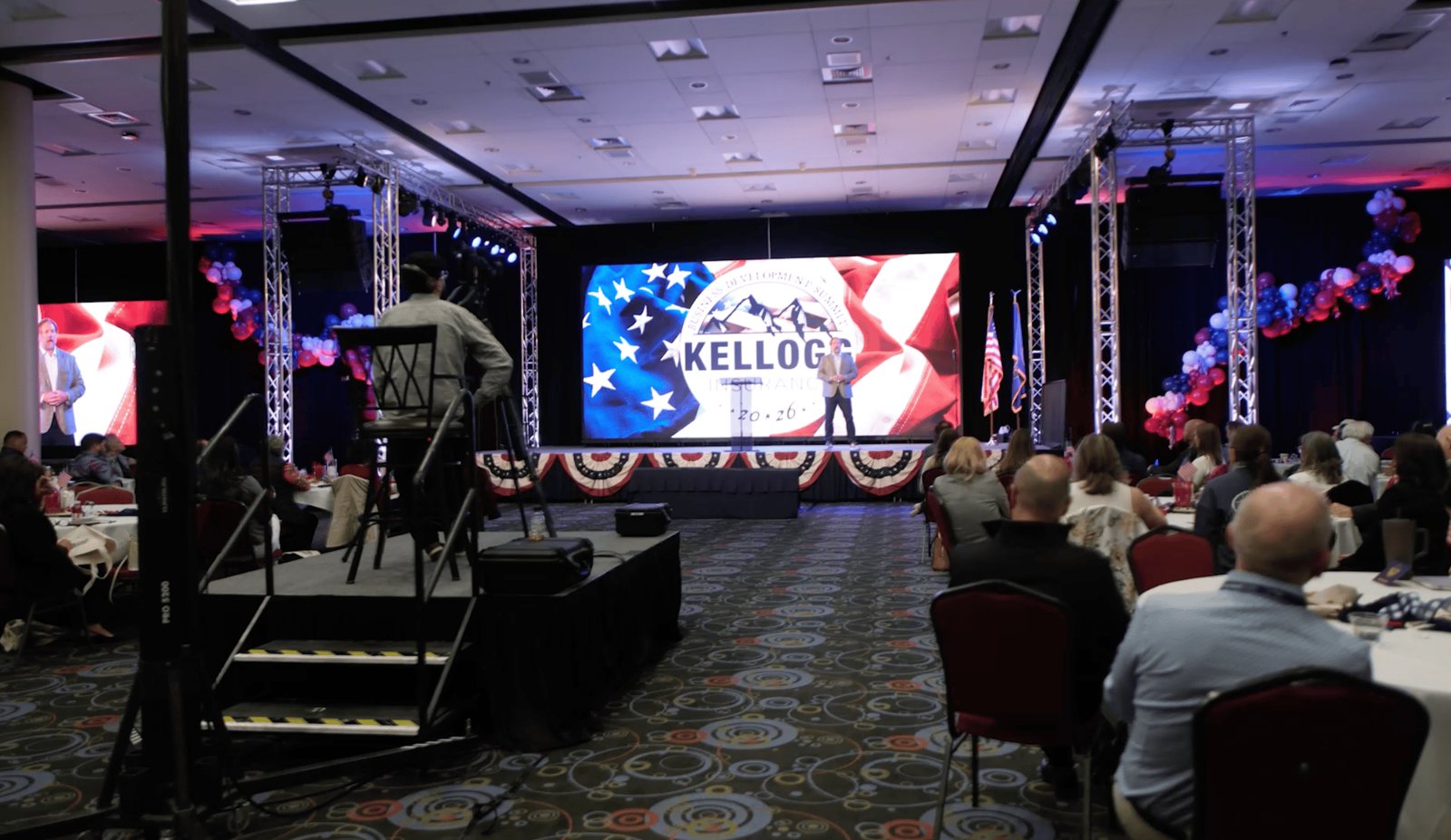 Wide view of the Kellogg general session, full room and main LED wall