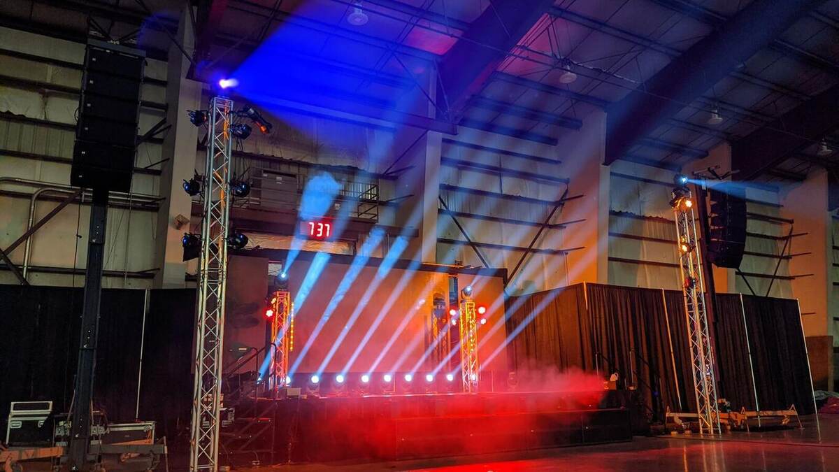 Concert lighting design with blue and red beams cutting through haze on a truss stage