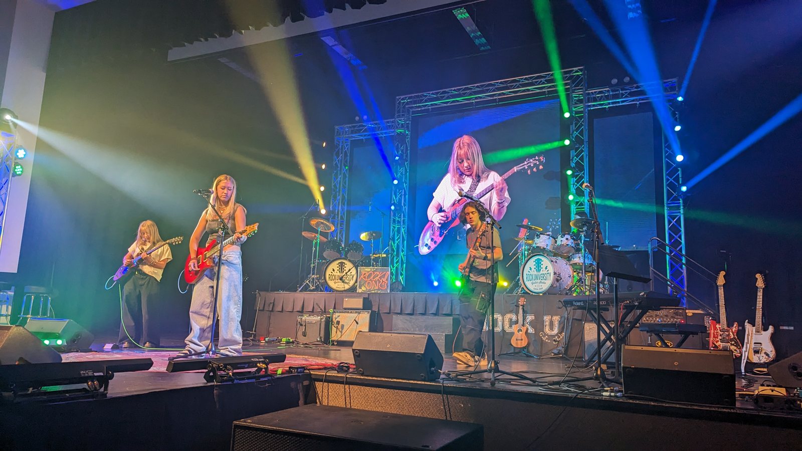 A band performing under stage lights at Rock U Live