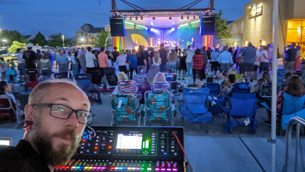 A True AV audio engineer monitoring a digital mixing console