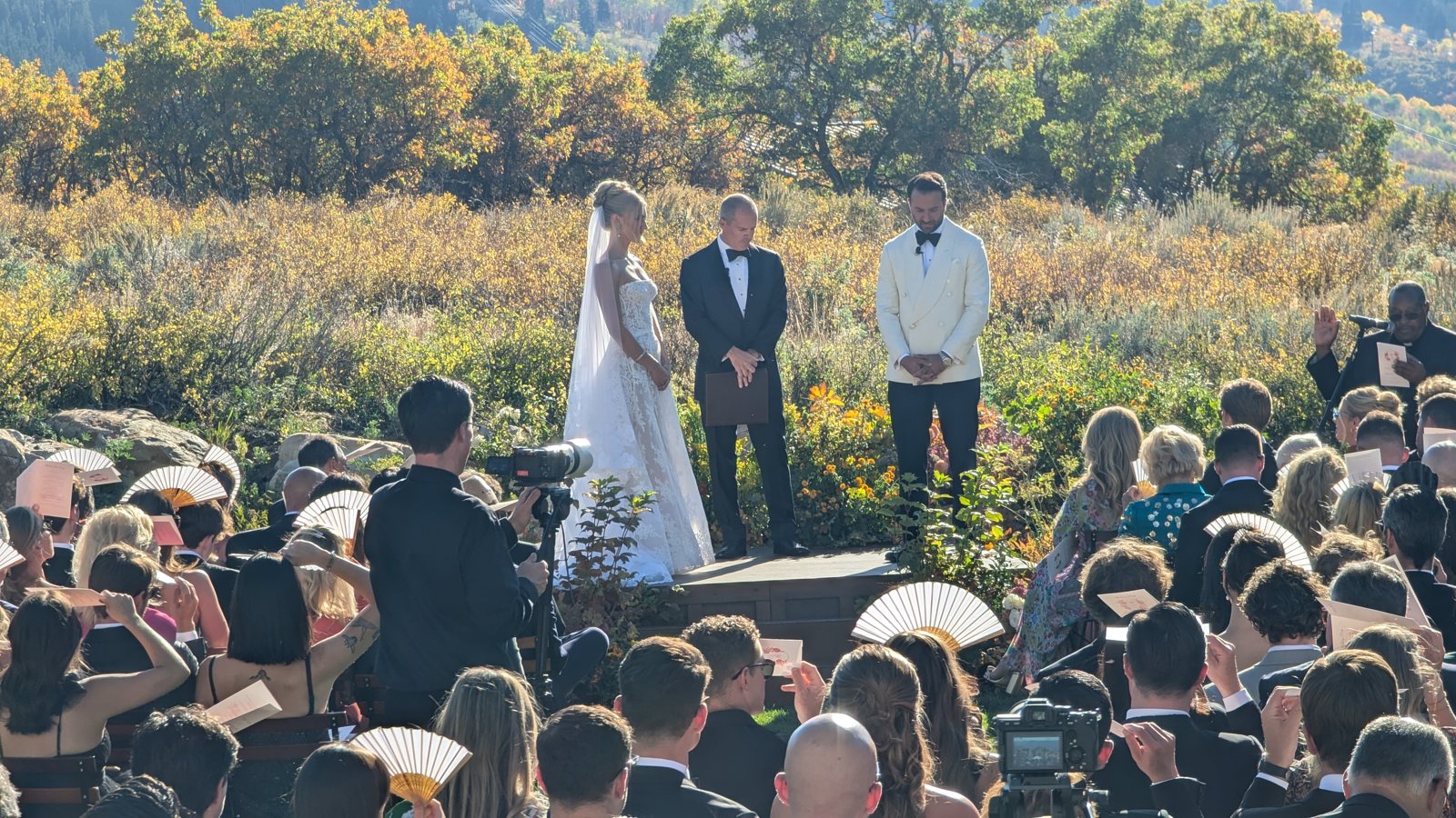An outdoor wedding ceremony with a mountain backdrop